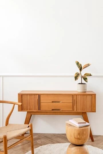 Aparador de madera de estilo nórdico con una planta y una silla de fibra